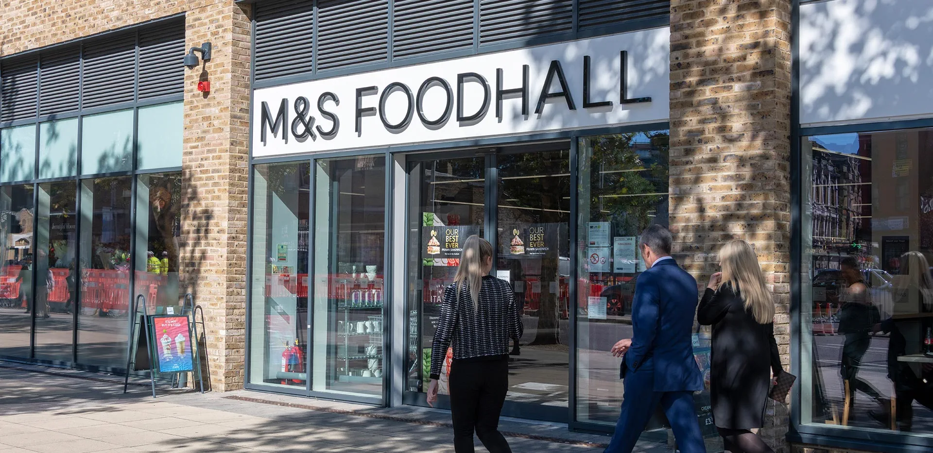 M&S Foodhall storefront near modern London apartments.