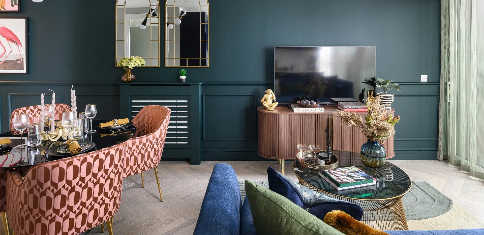 Modern open-plan living room with dark green wall paneling, luxury dining set, and elegant decor.