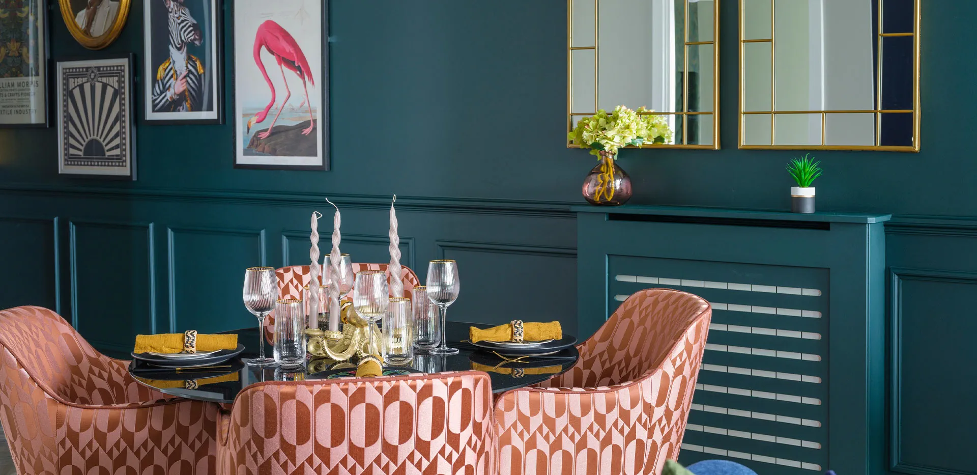 Elegant dining setup with stylish pink patterned chairs, black table, and dark green wall paneling.