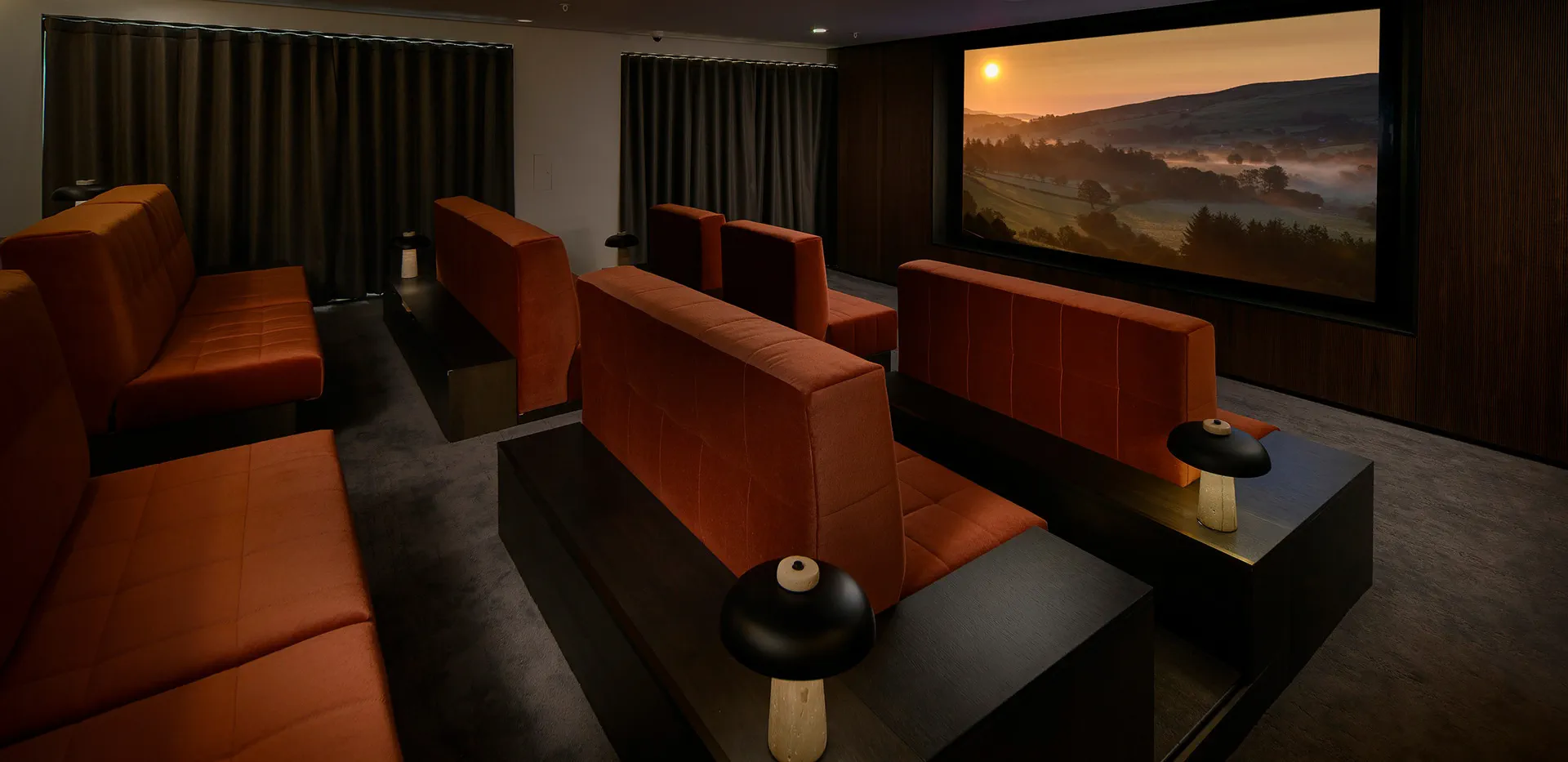 Private resident's cinema room with comfortable sofa seating and large projection screen