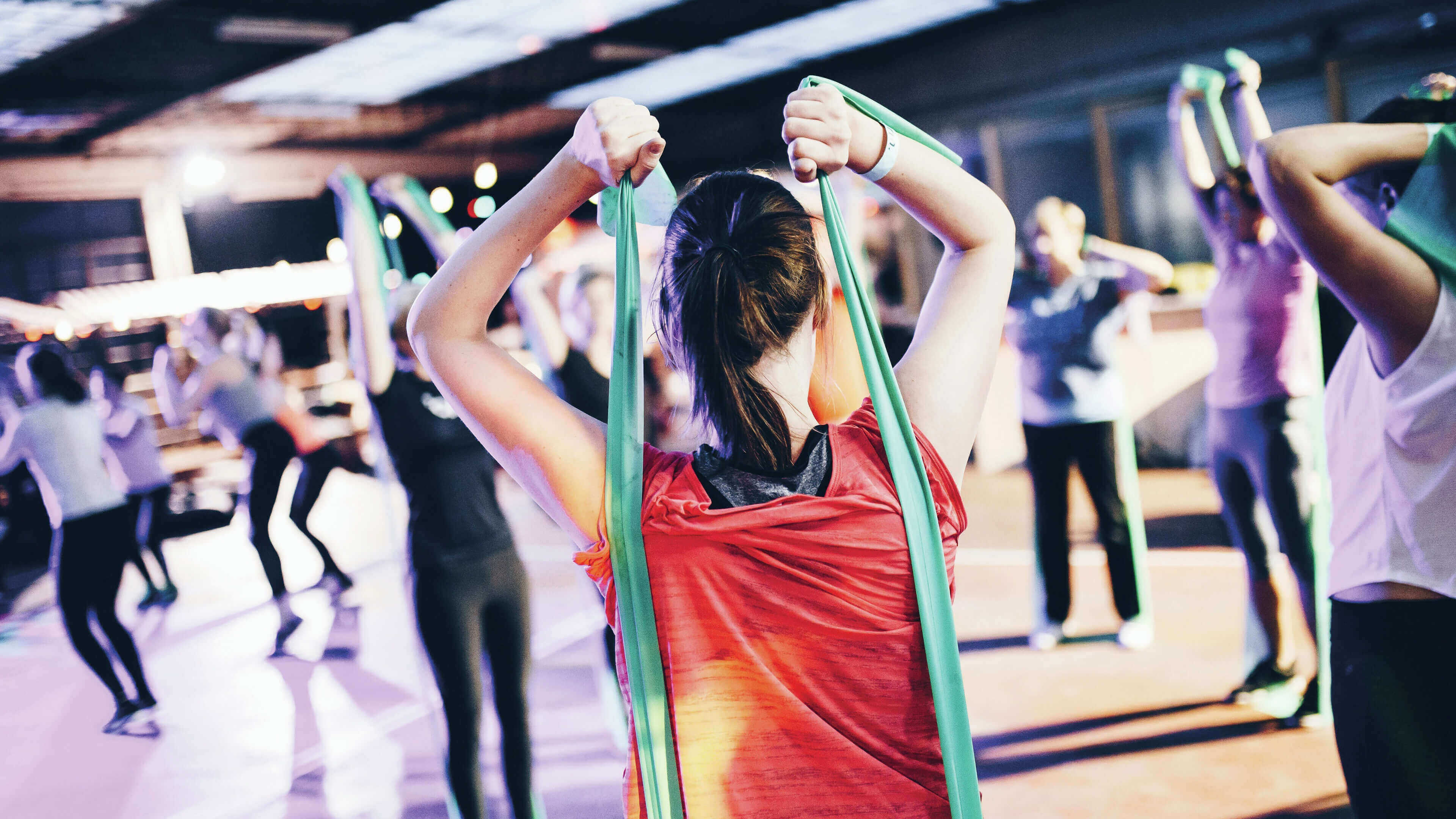 A modern London apartment gym amenity, showing people participating in a group resistance band class for residents.